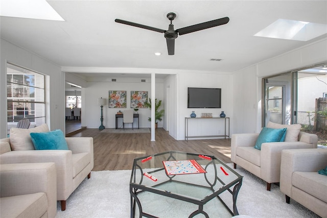 living room featuring visible vents, a ceiling fan, and light wood-type flooring