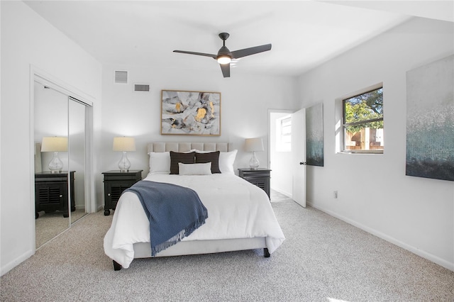 bedroom featuring a closet, visible vents, light colored carpet, and baseboards