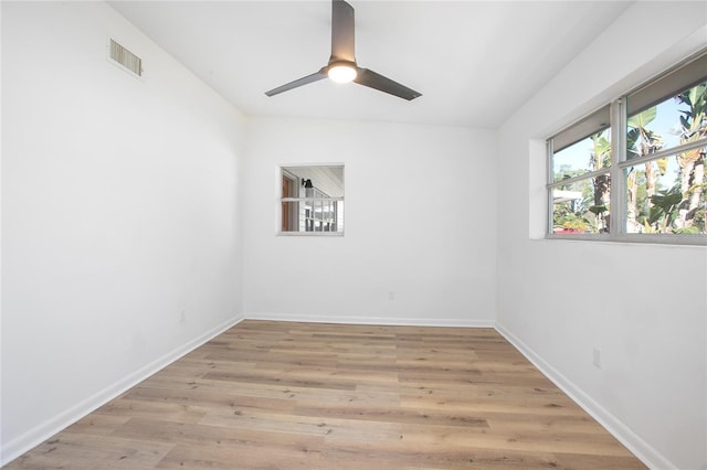 empty room with light wood-style flooring, baseboards, visible vents, and ceiling fan