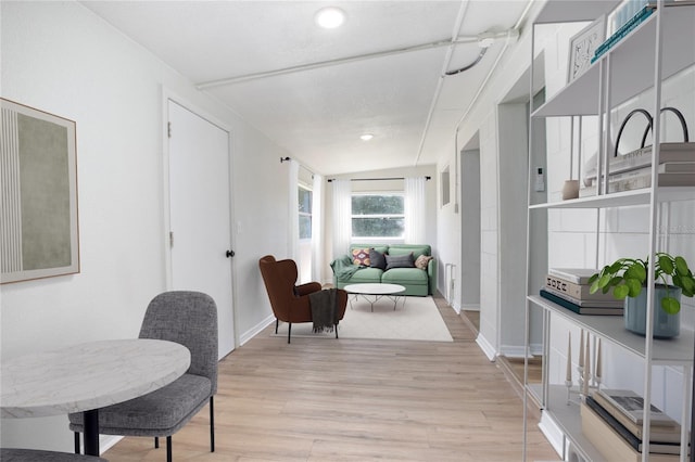 corridor featuring light wood finished floors and baseboards