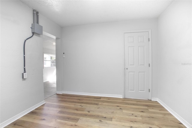 unfurnished room with baseboards and wood finished floors