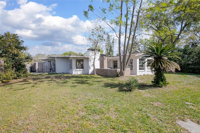 rear view of property with a yard and a chimney