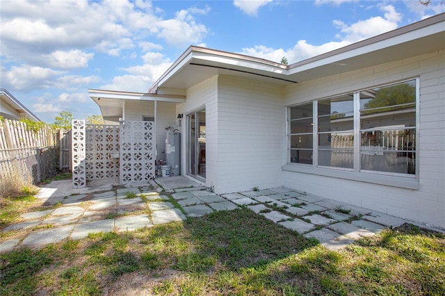 exterior space with water heater and fence