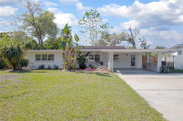 view of front of home with an attached carport, concrete driveway, a front yard, and fence