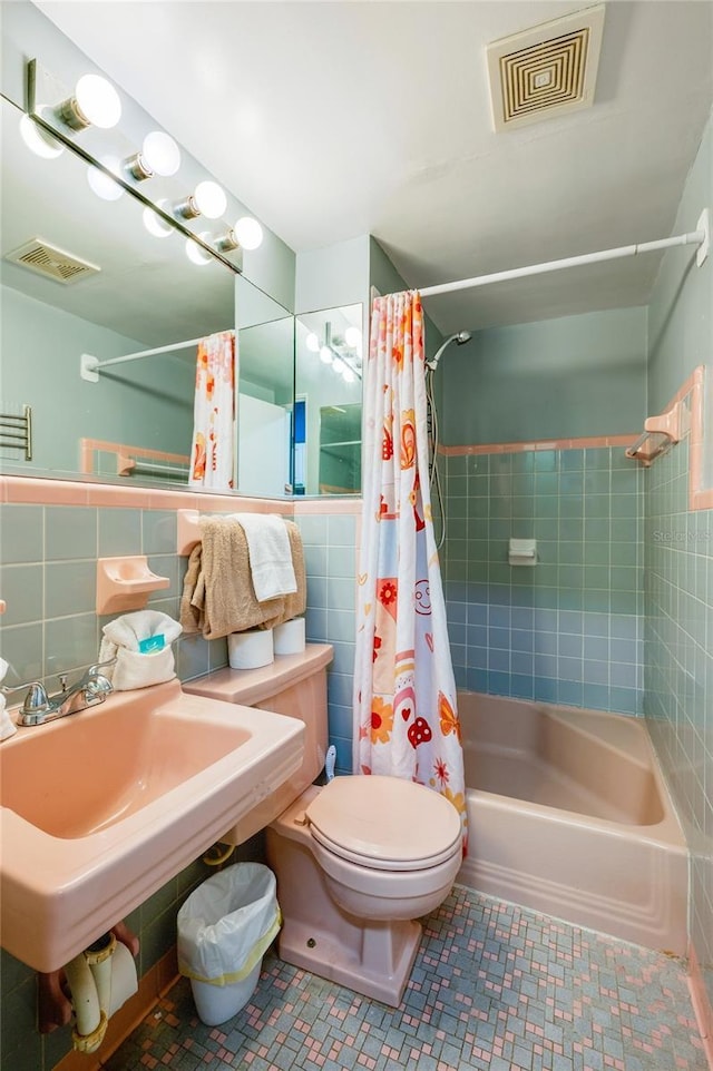 full bathroom featuring tile patterned flooring, visible vents, toilet, and tile walls