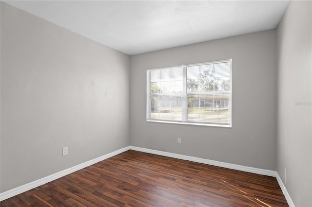 spare room with dark wood finished floors and baseboards