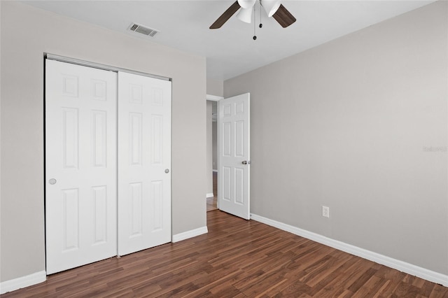 unfurnished bedroom featuring wood finished floors, visible vents, baseboards, ceiling fan, and a closet