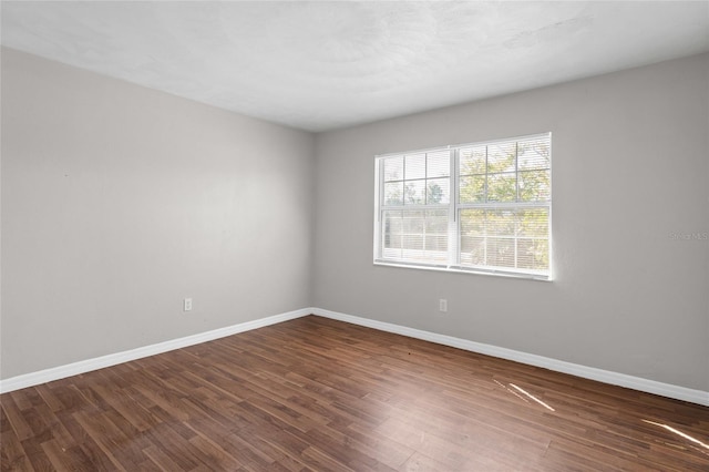 empty room with baseboards and wood finished floors