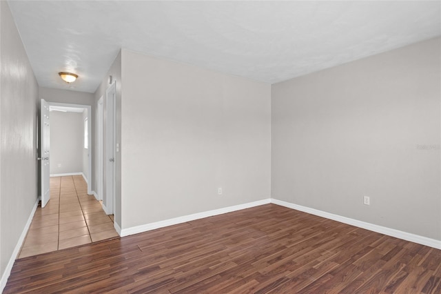 empty room featuring wood finished floors and baseboards