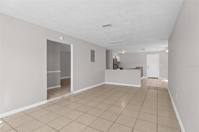 spare room featuring light tile patterned floors, visible vents, and baseboards