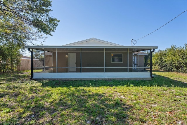 rear view of house with a yard and fence