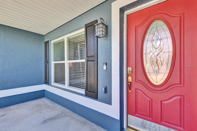 entrance to property featuring stucco siding and a porch