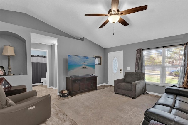 living room with vaulted ceiling, a ceiling fan, and baseboards