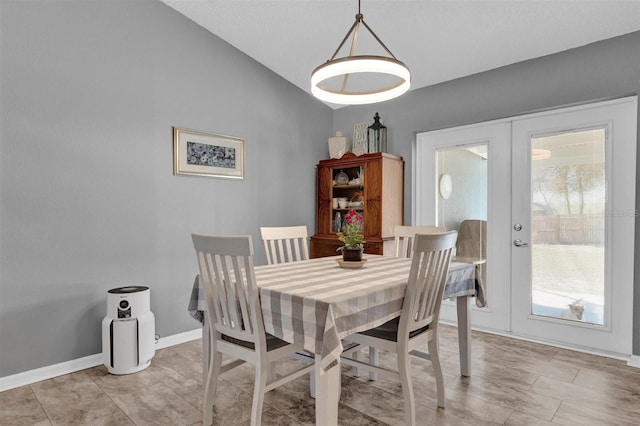 dining area featuring french doors, lofted ceiling, and baseboards