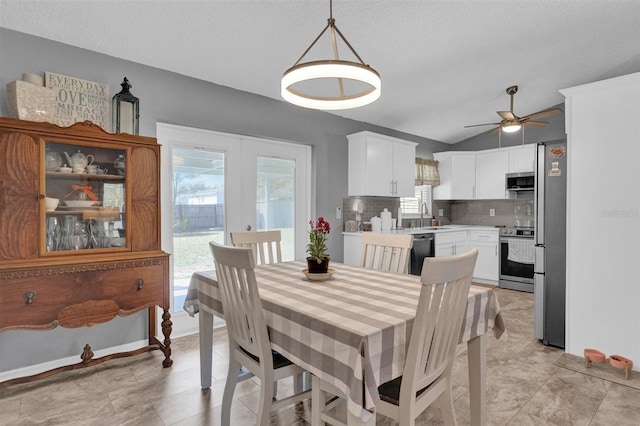 dining room with baseboards, lofted ceiling, french doors, a textured ceiling, and a ceiling fan