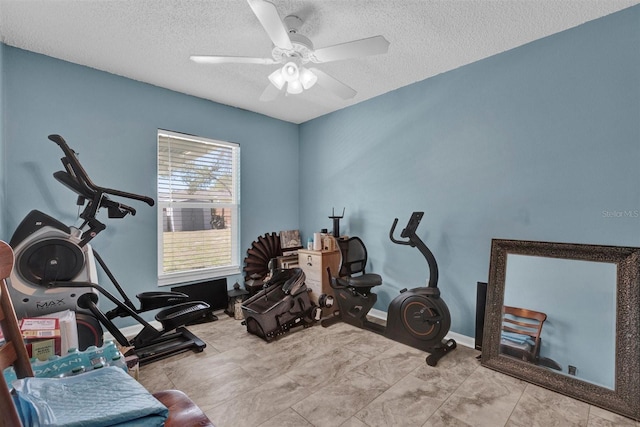 workout room with a textured ceiling, baseboards, and ceiling fan