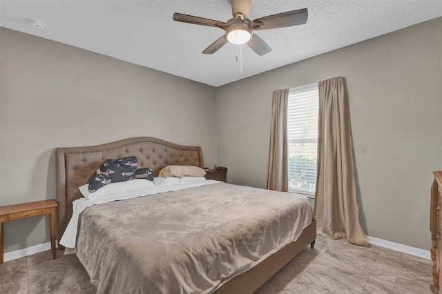 bedroom with a textured ceiling, baseboards, and ceiling fan