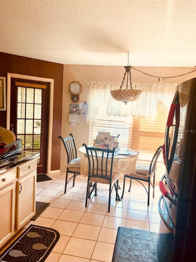 dining space with light tile patterned floors and a textured ceiling