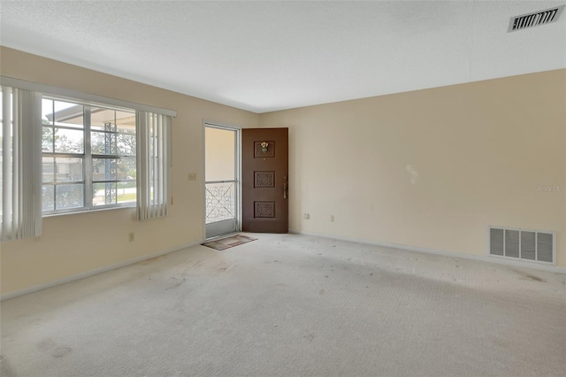 unfurnished room featuring visible vents, carpet floors, and baseboards