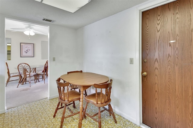 dining area with visible vents, baseboards, light floors, and a ceiling fan