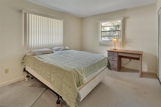 bedroom featuring carpet, baseboards, and a textured ceiling