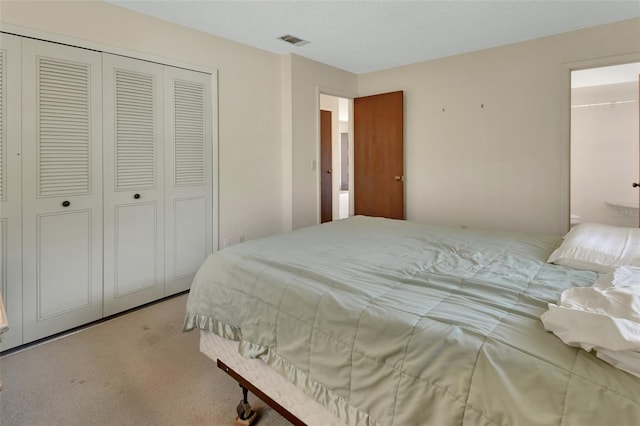 bedroom with a closet, visible vents, and carpet