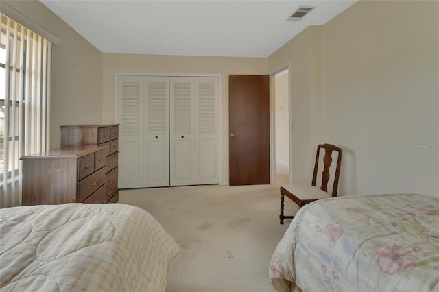 carpeted bedroom featuring a closet, visible vents, and multiple windows