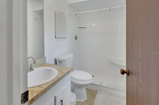 full bath featuring tiled shower, toilet, and vanity