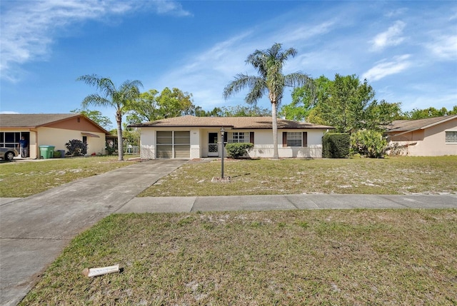 ranch-style home featuring a garage, concrete driveway, a front lawn, and stucco siding