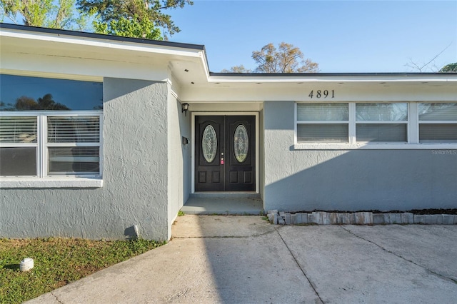 entrance to property with stucco siding