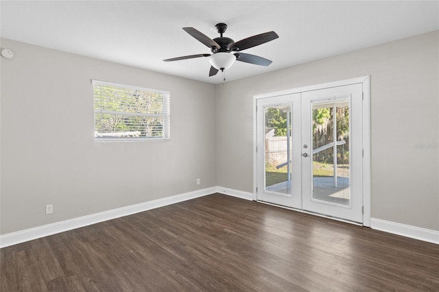 empty room with french doors, a ceiling fan, baseboards, and dark wood-style flooring