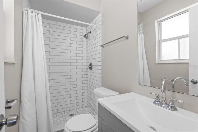 bathroom featuring a shower stall, toilet, and vanity