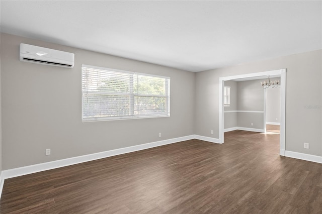 unfurnished room with dark wood-style floors, baseboards, a wall mounted air conditioner, and a chandelier