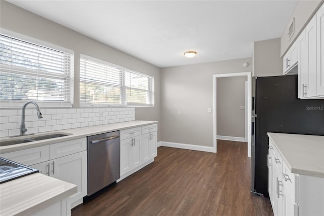 kitchen with dark wood finished floors, a sink, decorative backsplash, light countertops, and dishwasher