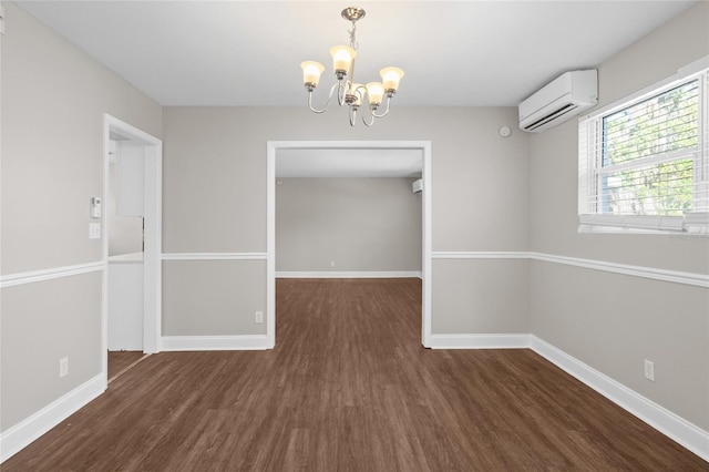 unfurnished dining area featuring baseboards, an AC wall unit, an inviting chandelier, and wood finished floors