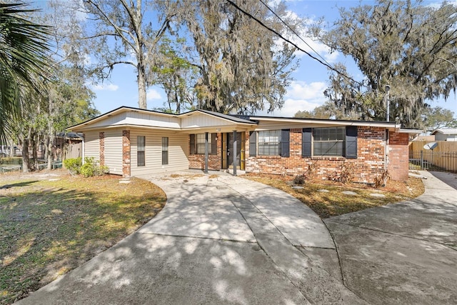 single story home with fence, brick siding, and driveway