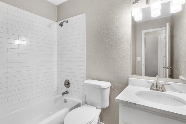 full bath with toilet, vanity,  shower combination, and a textured wall