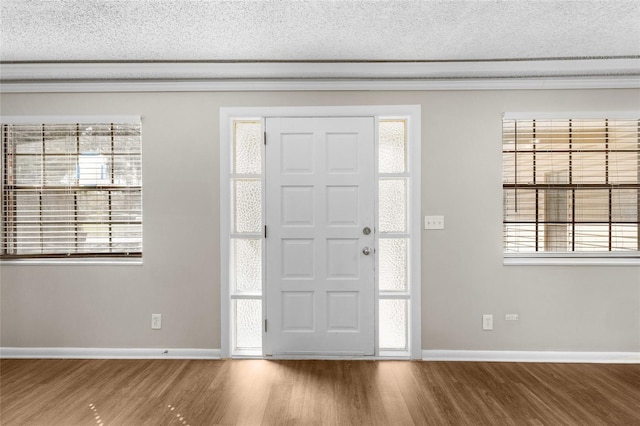 entrance foyer with baseboards, a textured ceiling, and wood finished floors