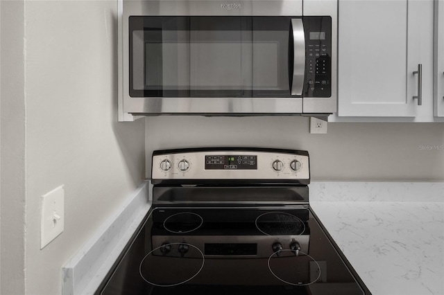 kitchen featuring white cabinets, stainless steel appliances, and light countertops