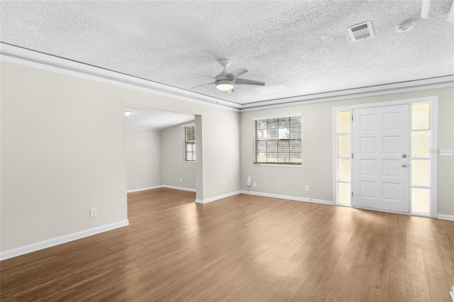 interior space featuring a textured ceiling, wood finished floors, visible vents, and ceiling fan