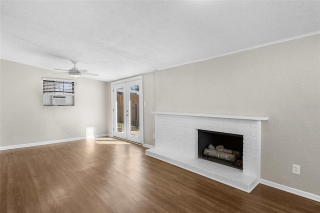 unfurnished living room featuring a brick fireplace, wood finished floors, and baseboards