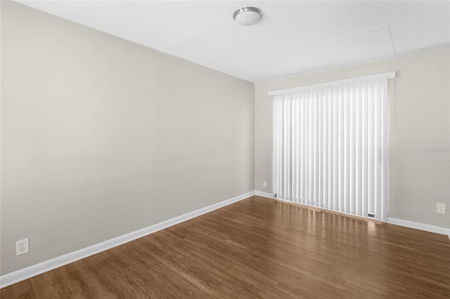 unfurnished room featuring baseboards and wood finished floors