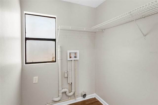 washroom featuring baseboards, washer hookup, wood finished floors, and laundry area