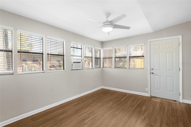 unfurnished room featuring ceiling fan, cooling unit, baseboards, and wood finished floors