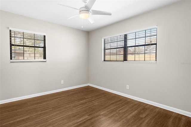 unfurnished room with a wealth of natural light, baseboards, and wood finished floors