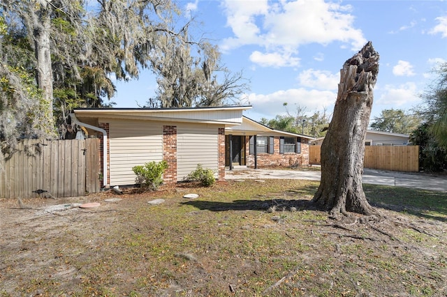 view of front facade with fence and brick siding