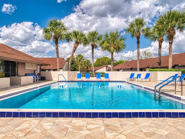 community pool featuring fence and a patio area