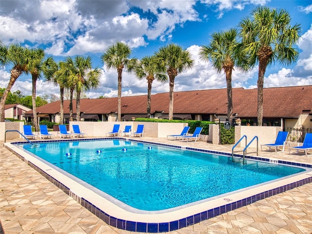 pool with a patio and fence