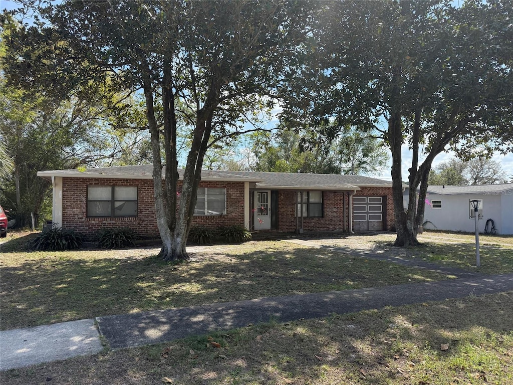 ranch-style home featuring brick siding and a front lawn