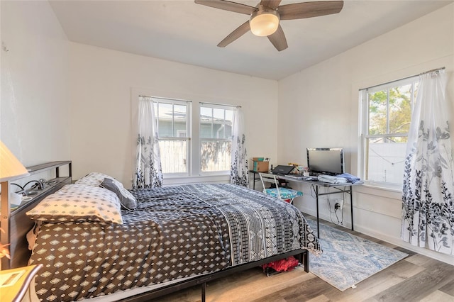bedroom with baseboards, ceiling fan, and wood finished floors